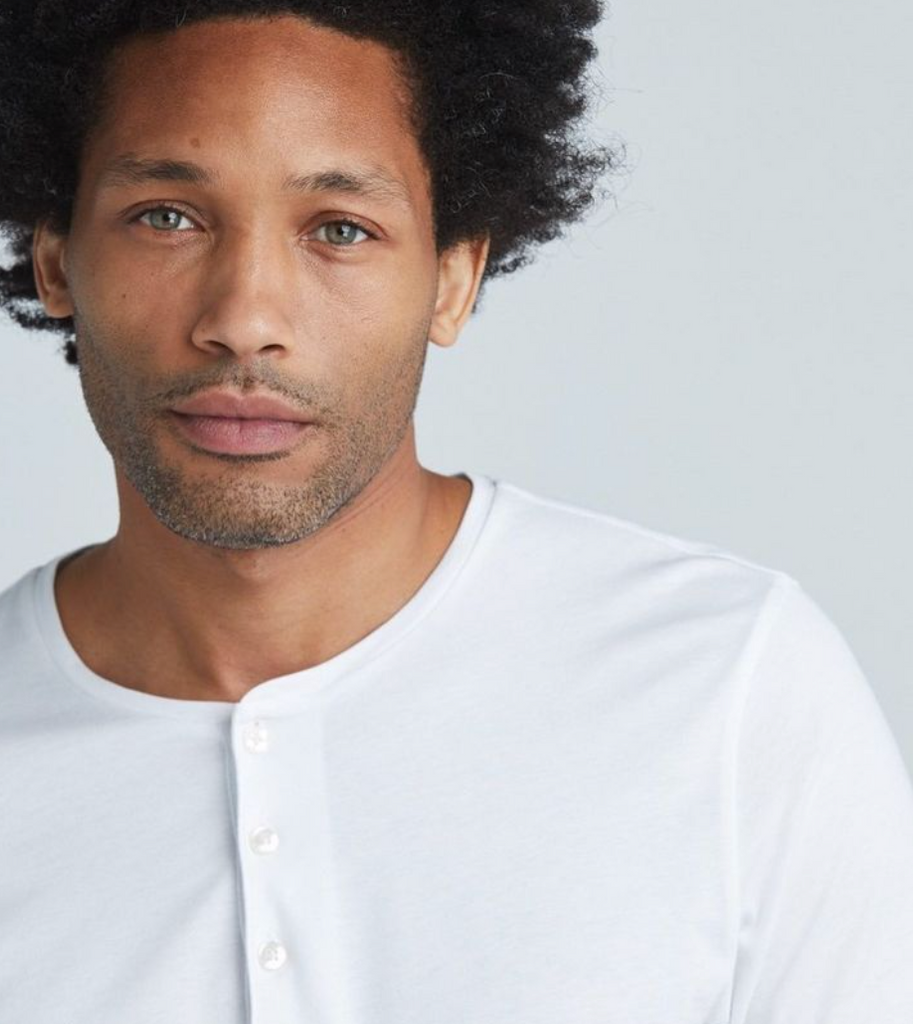 A man wearing a State of Matter sustainable classic white Henley shirt. 