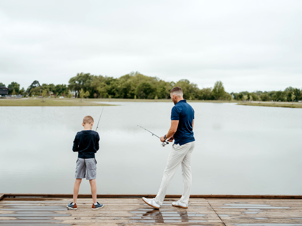Presumably a father and son fishing at a lake wearing a pair of men's State of Matter Chino pants in light grey 