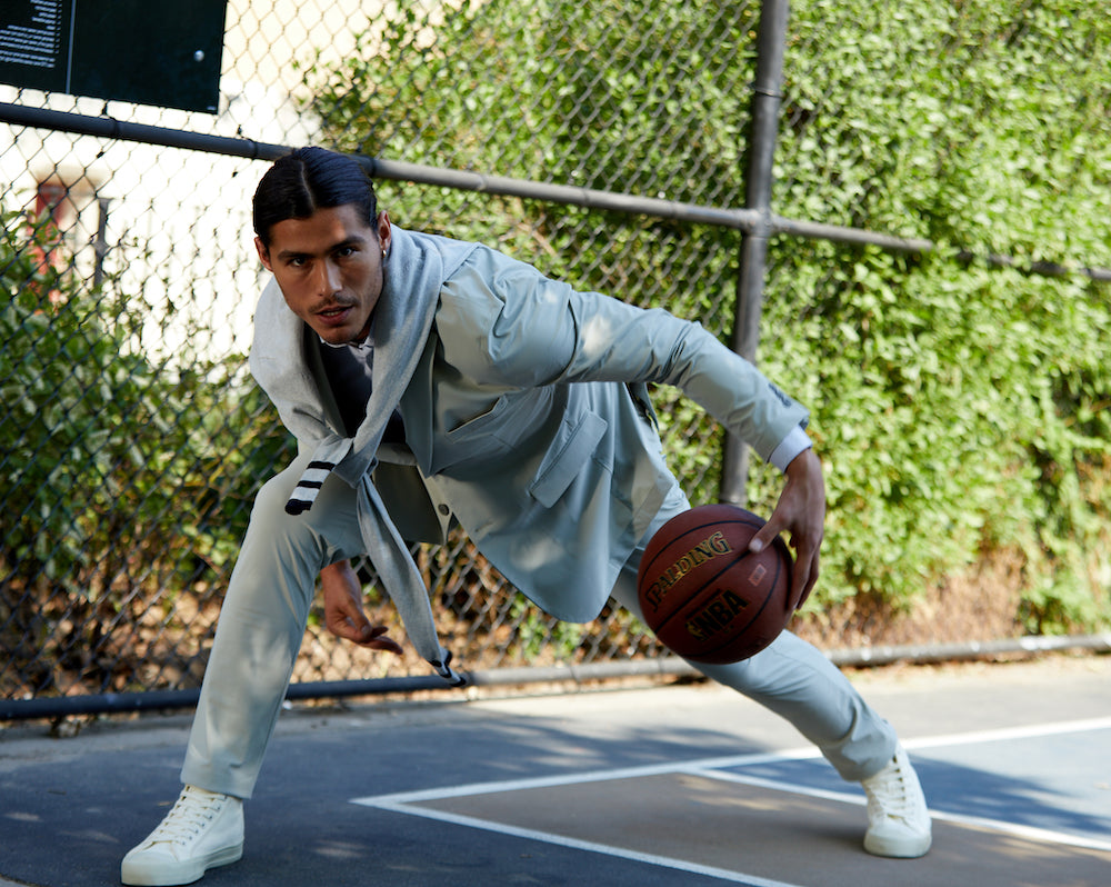Man playing basketball while wearing state of matter's men's sustainable suit jacket and chino pants