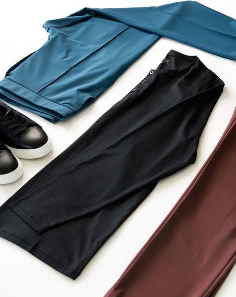 Image of clothing laid out against a white backdrop, a pair of State of Matter navy Chino Pants and sustainable black polo shirt 