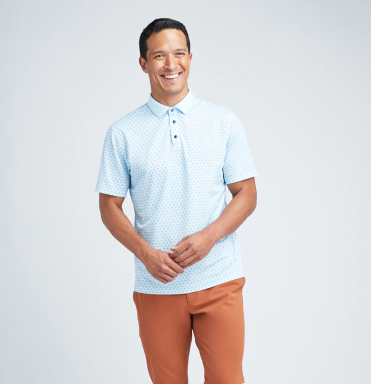 A smiling man wearing a State of Matter Men's Baby Blue Polo Shirt and sustainable copper chino pants 