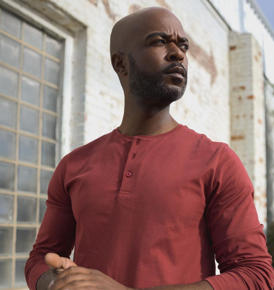 Men looking into the distance while wearing State of matter sustainable long sleeve red henley shirt