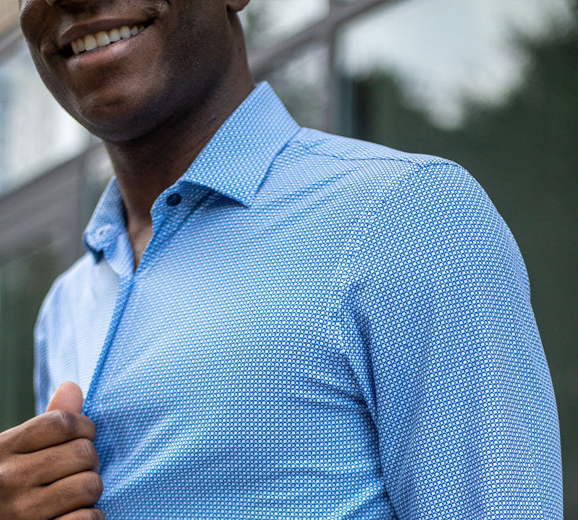 A close up of a smiling man wearing Sustainable Geo Print Teal and White Long-Sleeve Men's Dress Shirt.