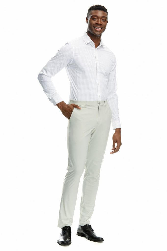 Full body picture of a man posing in his State of matter sustainable long sleeve grey checkered button down shirt, Gray chino pants, and black shoes over a white background