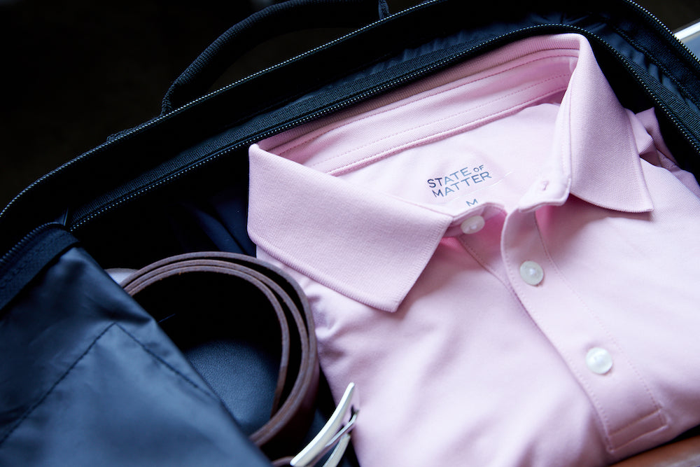 A men's pink polo by state of matter in a suitcase