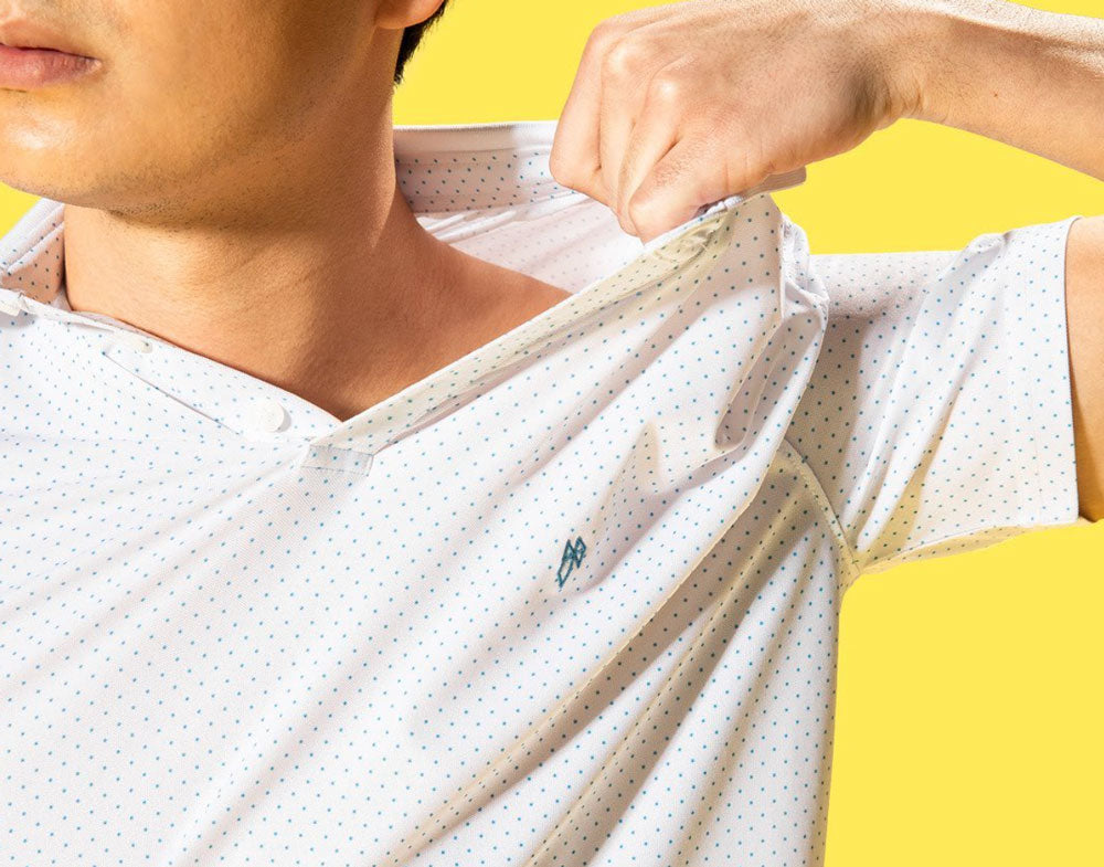 Men wearing a men's polo T-shirt and showing how it has a 360° stretch by pulling on the neck