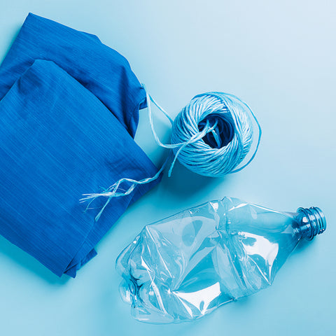 Picture of a water bottle, a ball of string, and a piece of state of matter clothing made from recycled water plastic water bottle