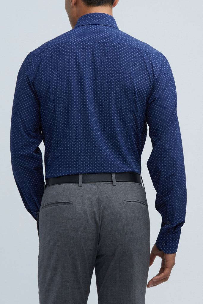 back shot of a man posing in his state of matter Navy blue button up shirt and gray chino pants